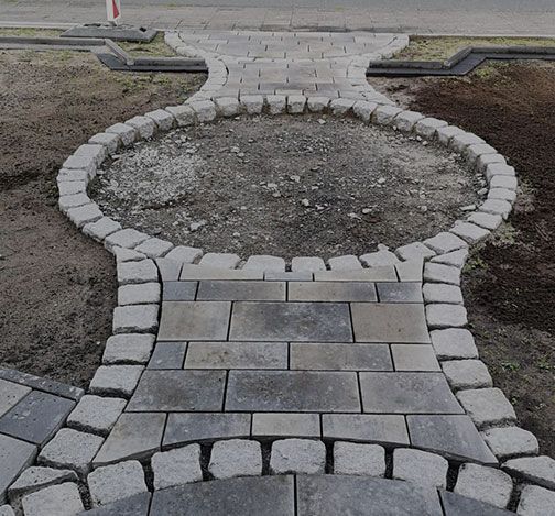 Geschwungene Pflasterfläche in einem Vorgarten mit Musterung