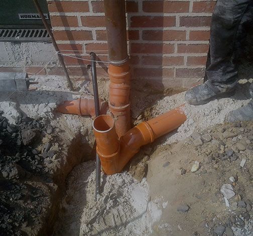 Mehrere Rohre an einer Gebäudewand für Abwasseranschluss