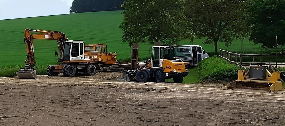 Baggerarbeiten auf einer Freifläche für den Bodenaufbau eines Reitplatzes.